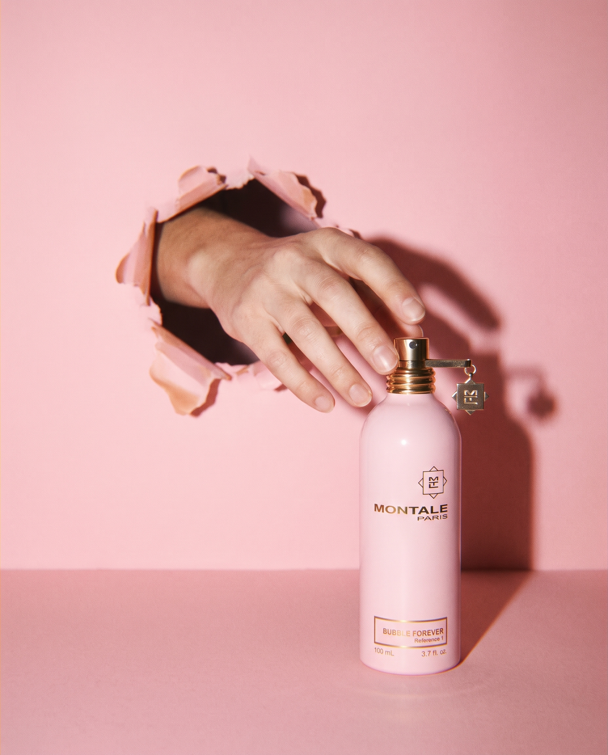 Montale Bubble Forever with a hand reaching through pink paper